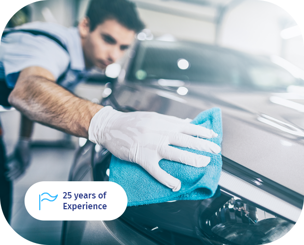 A man cleaning the hood of a car.